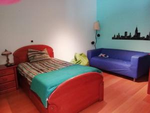 a bedroom with a bed and a blue couch at Global Guests in Sintra
