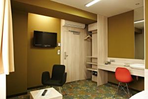 una stanza con due sedie, un lavandino e uno specchio di Kongres Hotel Roca a Košice