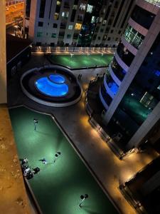 a swimming pool in the middle of a city at night at Panorama Sea view Studio in Ajman 