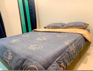 een bed met een blauwe deken en kussens erop bij Blue Ocean rooms, KOH SAMED, 5 minutes from the beach in Ko Samed