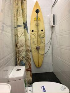 een badkamer met een surfplank aan de muur naast een toilet bij Blue Ocean rooms, KOH SAMED, 5 minutes from the beach in Ko Samed