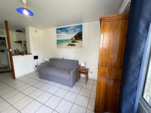 ein Wohnzimmer mit einem Sofa und einem Tisch in der Unterkunft La Plage Dorée in Saint-Pierre
