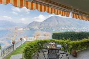 a patio with a table and chairs and a view of a mountain at Besana 9 on the Lake - Private garden & parking by Rent All Como in Moltrasio