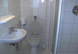 Un baño con un inodoro blanco y un lavabo. en Agency CSA Nürnberg, en Núremberg
