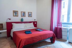 a bedroom with a red bed with two towels on it at Fruit Rooms in Rome