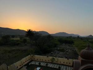 a view of a sunset from a house with a fence at PAGDANDI VILLA BY ALOHA in Udaipur