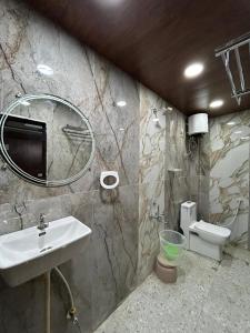 a bathroom with a sink and a toilet and a mirror at PAGDANDI VILLA BY ALOHA in Udaipur