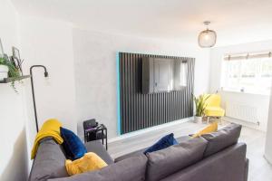 Captivating 3-Bedroom House with Netflix and Parking by HP Accommodation في Kibworth Harcourt: غرفة معيشة مع أريكة ومرآة