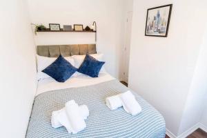 a bedroom with a bed with blue and white pillows at Captivating 3-Bedroom House with Netflix and Parking by HP Accommodation in Kibworth Harcourt