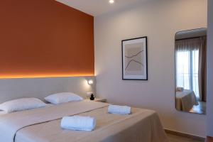 una camera da letto con un grande letto con due cuscini bianchi di Lodge Apartments a Città di Zante