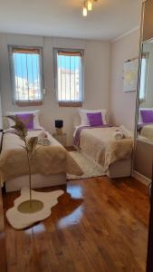 a bedroom with two beds and a palm tree in it at Apartment Domino in Split
