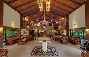 un ampio soggiorno con soffitti e mobili in legno di The Fern Gir Forest Resort, Sasan Gir - A Fern Crown Collection Resort a Sasan Gir