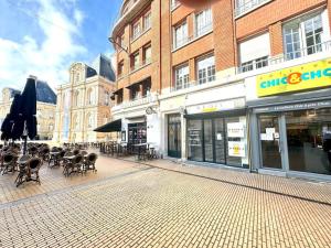 een lege straat met stoelen, tafels en gebouwen bij Magnifique 3 Chambres - Parking - Hyper Centre - Gare in Amiens