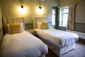 a room with two beds in a room at Ye Old Boote Inn in Whittington