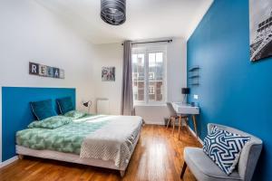 een blauwe en witte slaapkamer met een bed en een bureau bij Magnifique 3 Chambres - Parking - Hyper Centre - Gare in Amiens