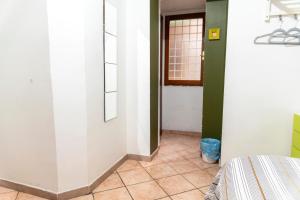 a hallway with green and white walls and a tile floor at Fruit Rooms in Rome