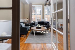 een woonkamer met een bank en een tafel bij Magnifique 3 Chambres - Parking - Hyper Centre - Gare in Amiens