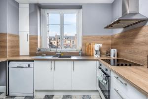 een keuken met witte kasten en een raam bij Magnifique 3 Chambres - Parking - Hyper Centre - Gare in Amiens +24 foto's