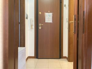 uma porta castanha num quarto com piso em azulejo em La Mansarda di Pino em Trieste