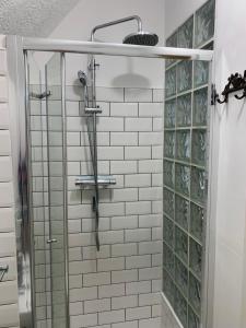 a shower with a glass door in a bathroom at Ocean view double with ensuite, with access to private garden and bike store in Kent