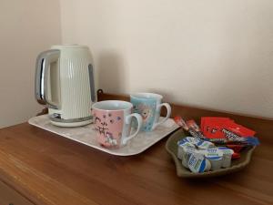a counter with two coffee mugs and a toaster at Ocean view double with ensuite, with access to private garden and bike store in Kent