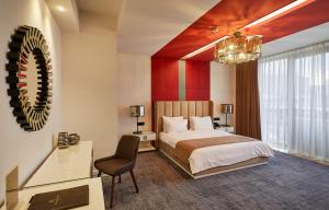 Habitación de hotel con cama y lámpara de araña. en Aghababyan's Hotel, en Ereván