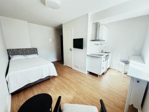 Habitación blanca con cama y escritorio en VILMSI 52 APARTMENTS, en Tallin