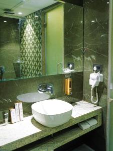 a bathroom with a sink and a large mirror at Enrise by Sayaji Nagpur in Nagpur