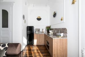 プシェムィシルにあるRetro Apartamentyの白い壁のキッチン(黒い冷蔵庫付)