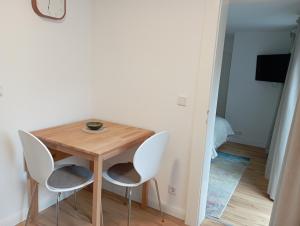 a small wooden table and two white chairs in a room at Schenkgasse 4 in Amorbach