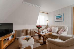 un salon avec un canapé et une télévision dans l'établissement Jule im Haus Wega, à Westerland