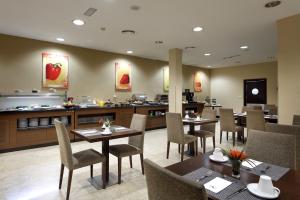 a restaurant with tables and chairs and a counter at Exe Tartessos in Huelva