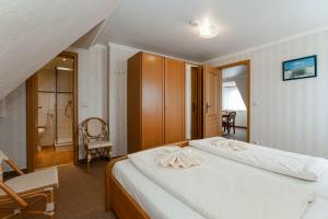 une chambre avec un grand lit blanc et une chaise dans l'établissement Jule im Haus Wega, à Westerland