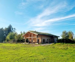 eine alte Scheune mit Grasdach auf einem Feld in der Unterkunft EddyLou Ranch in Slöinge