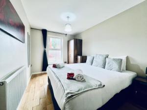 Un dormitorio con una cama grande con dos animales de peluche. en Lovely 4 bed (sleeps 8) apartment close to city, en Mánchester