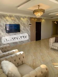 ein Wohnzimmer mit Sofas und einem TV an der Wand in der Unterkunft شقة جديدة بالكامل in Port Said