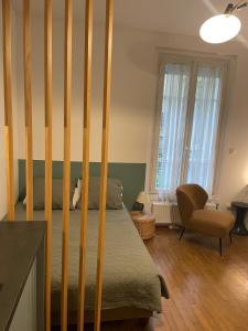 - une chambre avec un lit doté de poteaux en bois dans l'établissement Studio Paris tour Eiffel, à Paris