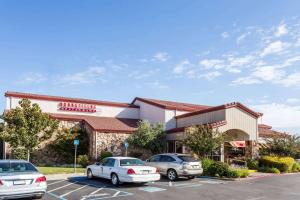 una tienda con coches estacionados en un estacionamiento en Super 8 by Wyndham Sacramento, en Sacramento