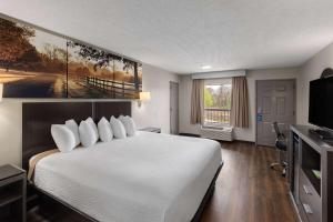 a hotel room with a large bed and a television at Days Inn by Wyndham Childersburg in Childersburg