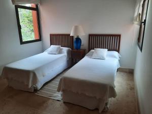 1 dormitorio con 2 camas y ventana en Chalet moderno en Sotogrande costa, en San Roque