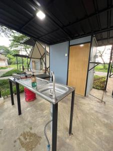 a metal sink in a room with a building at Glamping at Xscape Tambun in Tambun