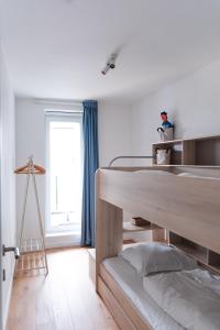 a bedroom with a bunk bed and a window at Flat White - Luxe app aan zee met terras & parking in De Haan