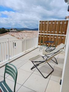 eine Terrasse mit Stühlen und Tischen auf dem Dach in der Unterkunft Appartement avec Terrasse in Cléon-dʼAndran