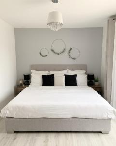 ein Schlafzimmer mit einem großen weißen Bett mit weißen Kissen in der Unterkunft Maison Paris Jeux Olympiques in Othis