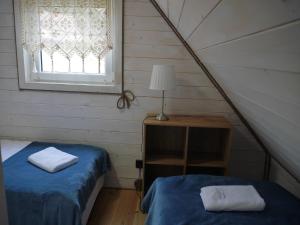 um quarto com duas camas e um candeeiro e uma janela em Dziedziniec Karkonoszy em Podgórzyn