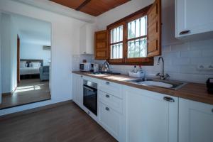 a kitchen with white cabinets and a sink at Casa Amarilla Casitas in Alhaurín el Grande