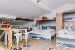 a room with two bunk beds and a desk at Guggi´s Emporeon Allgäu in Germaringen