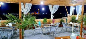 ein Restaurant mit Tischen, Stühlen und Pflanzen in der Unterkunft Naqshband in Buxoro