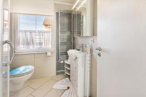 baño con aseo y lavabo y ventana en Apartment City, en Radolfzell am Bodensee