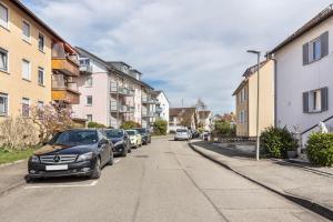 una calle con coches estacionados al costado de la carretera en Apartment City, en Radolfzell am Bodensee